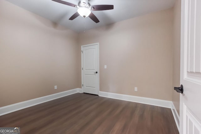 unfurnished room featuring a ceiling fan, baseboards, and dark wood-style floors