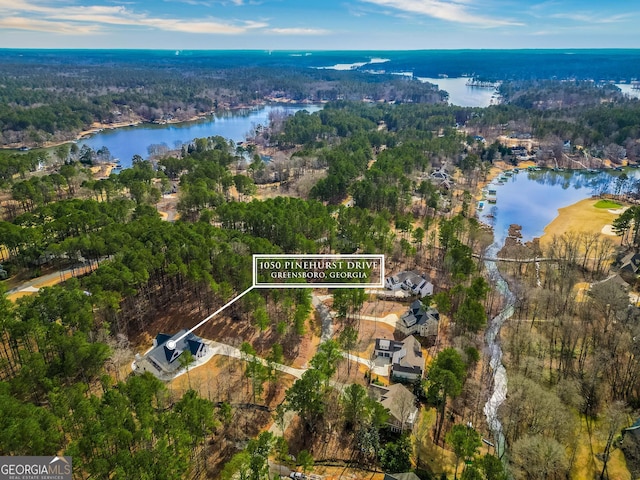 birds eye view of property featuring a wooded view and a water view
