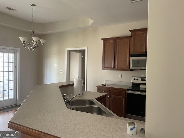 kitchen with visible vents, a sink, light countertops, appliances with stainless steel finishes, and a tray ceiling