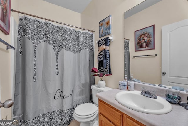 bathroom featuring toilet, curtained shower, and vanity