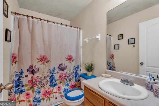 bathroom featuring toilet, curtained shower, and vanity