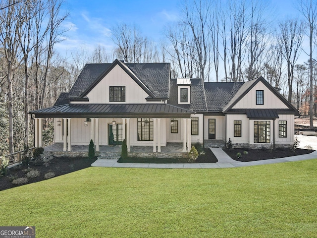 rear view of property with a yard, a porch, and a standing seam roof