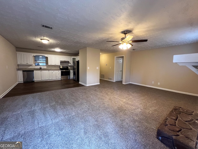 unfurnished living room with baseboards, visible vents, dark colored carpet, and a textured ceiling