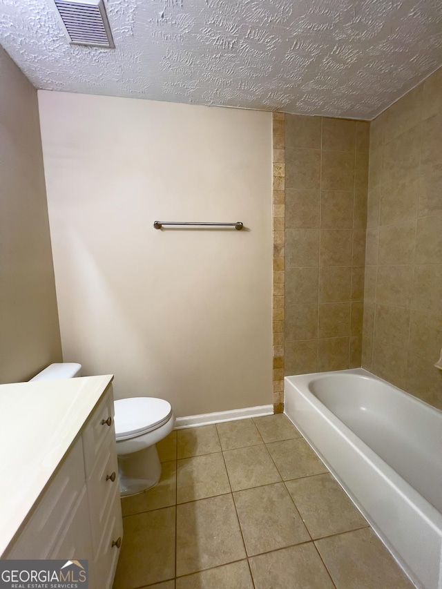 bathroom featuring toilet, visible vents, a textured ceiling, and tile patterned floors