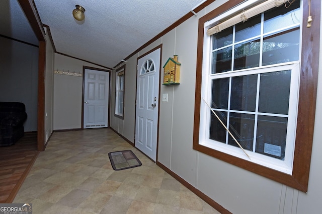 interior space with crown molding, a textured ceiling, vaulted ceiling, and baseboards