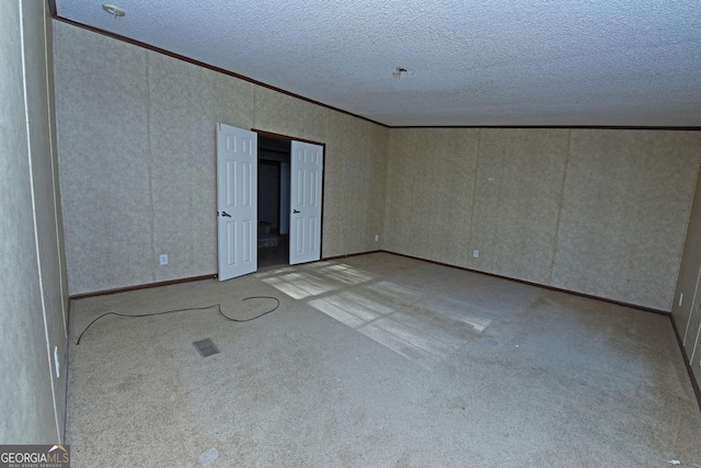 unfurnished room featuring ornamental molding, carpet, and a textured ceiling
