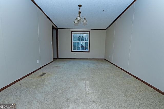 carpeted spare room with a textured ceiling, visible vents, and baseboards