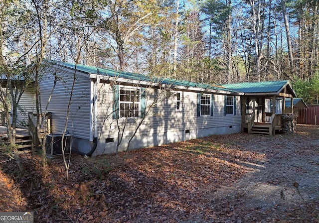 exterior space with metal roof, central AC unit, and crawl space