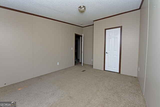unfurnished bedroom with carpet flooring, crown molding, and a textured ceiling