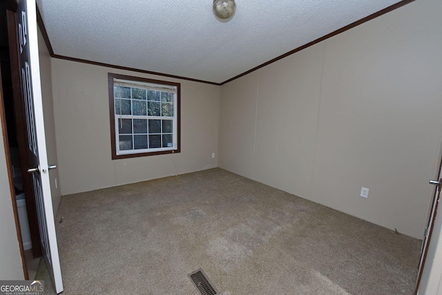 carpeted spare room with visible vents, crown molding, and a textured ceiling