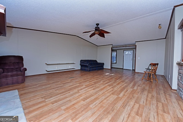 living area with a ceiling fan, lofted ceiling, a textured ceiling, and wood finished floors