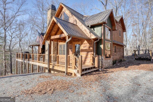 back of property featuring a chimney and a deck