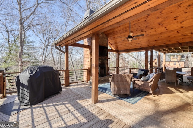 wooden deck with ceiling fan, an outdoor stone fireplace, area for grilling, a gazebo, and outdoor dining space