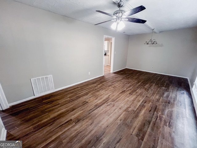 spare room featuring baseboards, visible vents, dark wood finished floors, a textured ceiling, and ceiling fan with notable chandelier