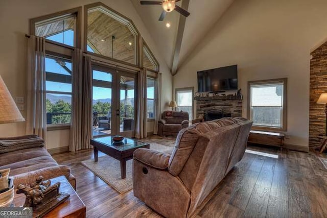 living room with high vaulted ceiling, french doors, a fireplace, and hardwood / wood-style flooring