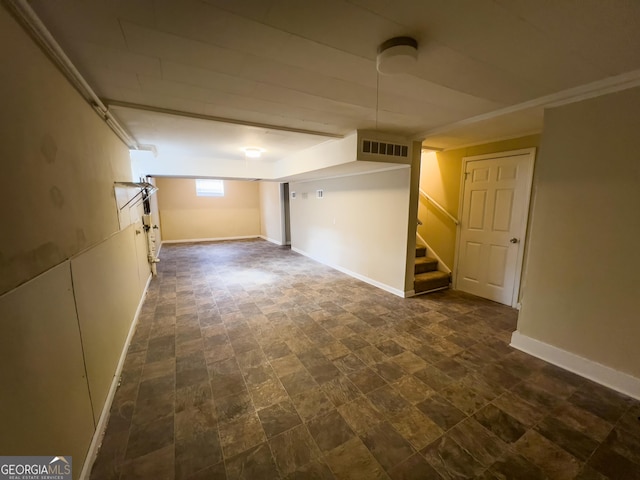 basement featuring baseboards, visible vents, and stairs