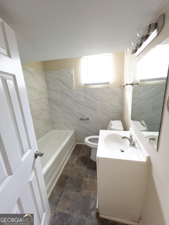 bathroom featuring toilet, vanity, and tile walls