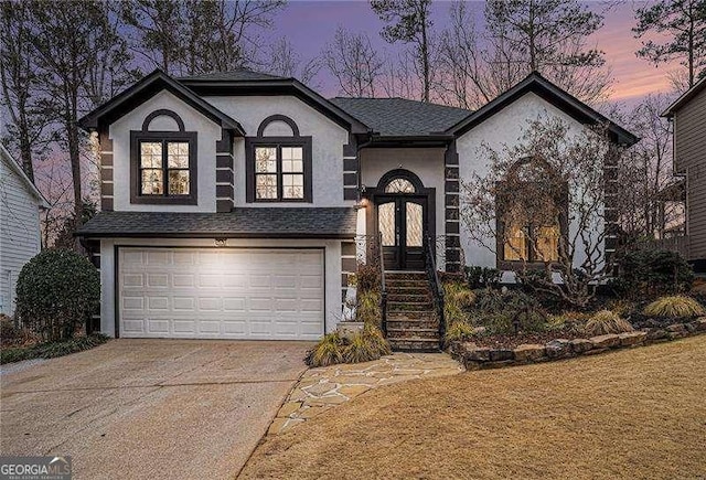 view of front of property with concrete driveway, stucco siding, a shingled roof, and an attached garage