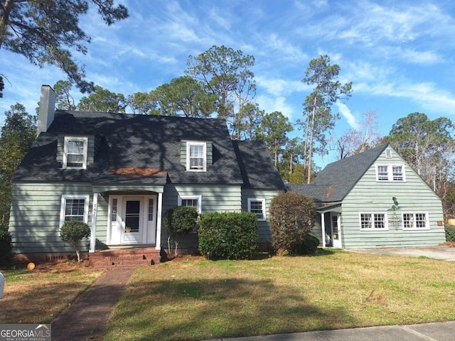 view of front of property with a front lawn and roof with shingles