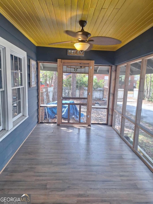 unfurnished sunroom featuring wooden ceiling and a ceiling fan