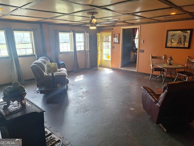 living area featuring ceiling fan and concrete flooring