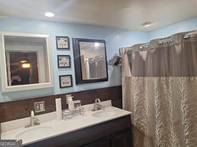 full bathroom with double vanity, curtained shower, and a sink