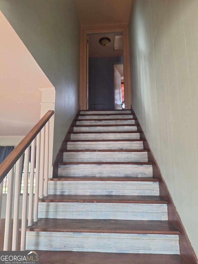 staircase with wood walls