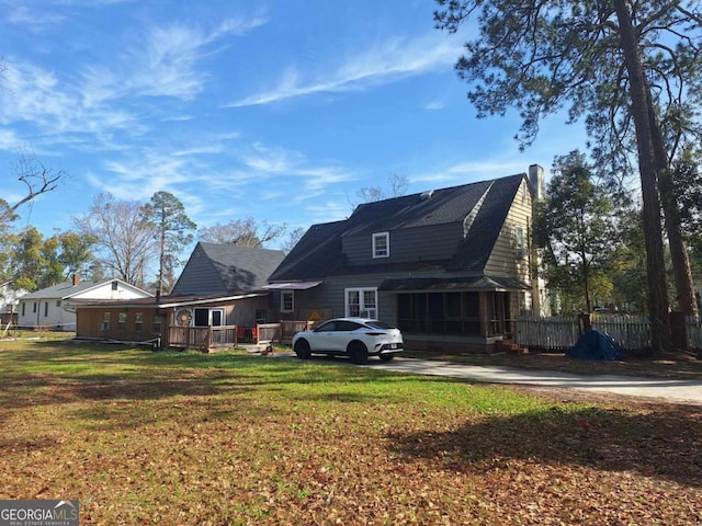 rear view of house featuring a yard and fence