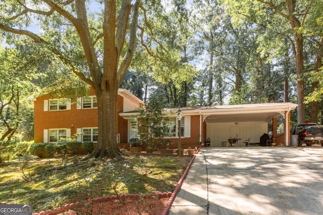 tri-level home with concrete driveway and brick siding