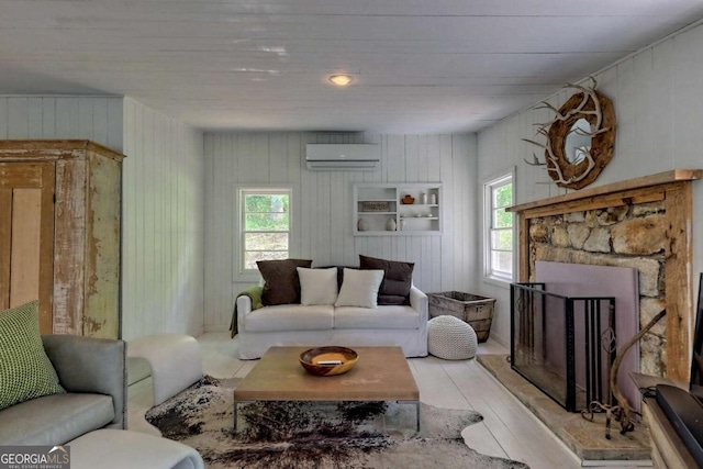 living room with a fireplace with raised hearth, light wood finished floors, and a wall mounted air conditioner