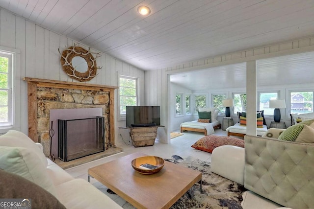 living room featuring vaulted ceiling, a stone fireplace, and wood ceiling