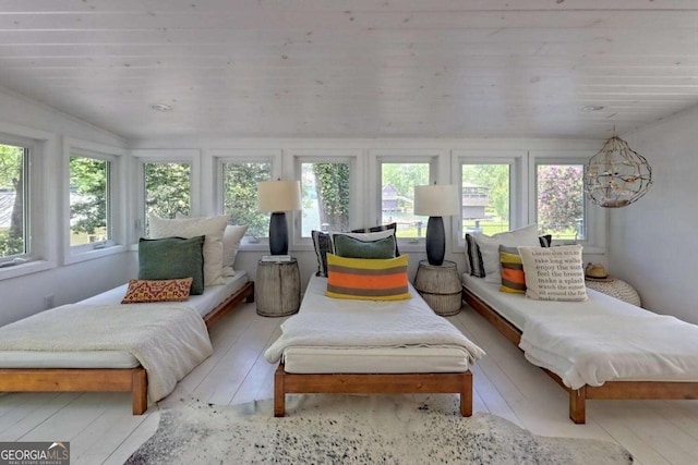 sunroom / solarium featuring a healthy amount of sunlight and wooden ceiling