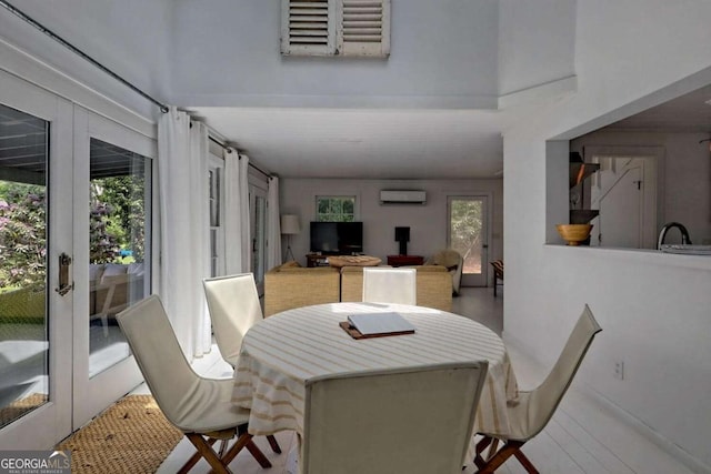 dining room featuring a high ceiling, a wall mounted AC, and wood finished floors