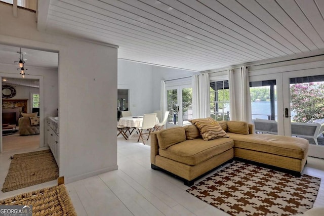 living area with wood ceiling, vaulted ceiling, french doors, light wood-type flooring, and a fireplace