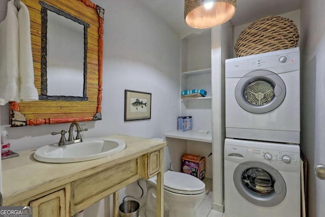 laundry room with stacked washer / dryer, laundry area, and a sink