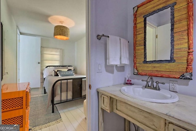 bathroom featuring wood finished floors, connected bathroom, and vanity