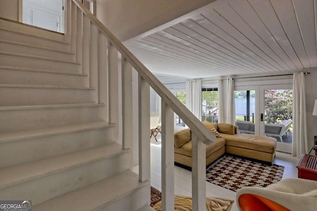 interior space with french doors, a water view, and wooden ceiling