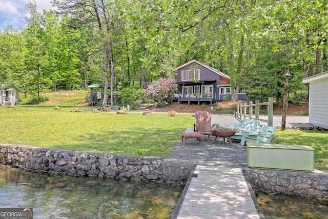 dock area with a water view and a yard