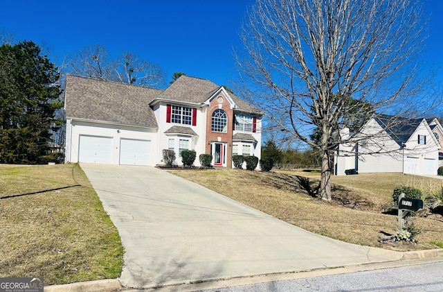 colonial inspired home with a garage, concrete driveway, brick siding, and a front yard