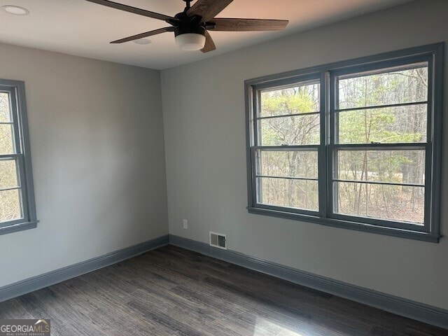 empty room featuring plenty of natural light, visible vents, and baseboards