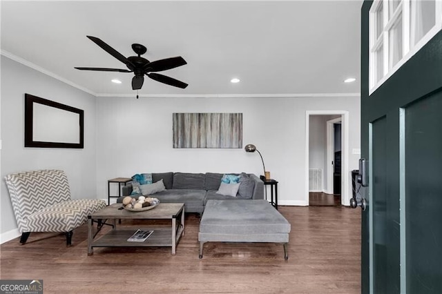 living area with ornamental molding, baseboards, and wood finished floors