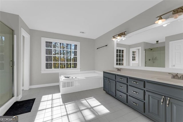 full bath featuring double vanity, a stall shower, a garden tub, tile patterned flooring, and a sink