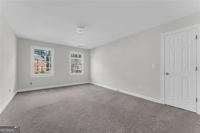 carpeted empty room with baseboards