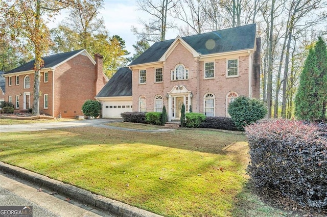 view of front of home featuring a garage, driveway, brick siding, and a front yard