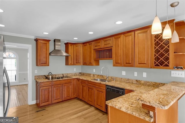 kitchen with wall chimney exhaust hood, light stone counters, a peninsula, pendant lighting, and a sink