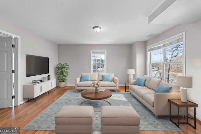 living room with baseboards and light wood-style floors