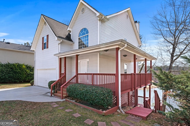 view of front facade with a garage, driveway, a porch, and a chimney