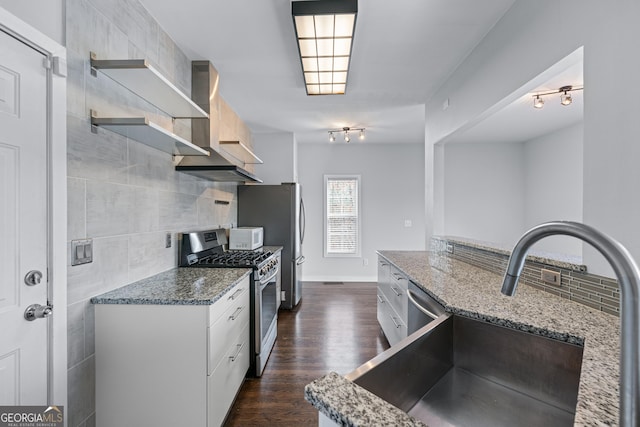 kitchen with open shelves, stainless steel appliances, backsplash, white cabinetry, and light stone countertops