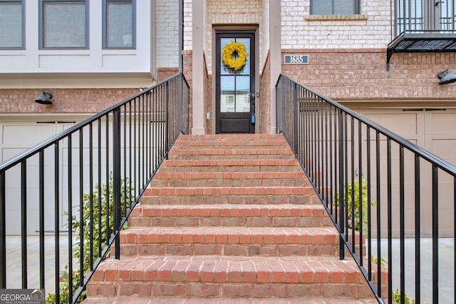 entrance to property featuring brick siding and an attached garage