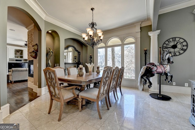 dining room with ceiling fan with notable chandelier, light tile patterned floors, baseboards, and crown molding